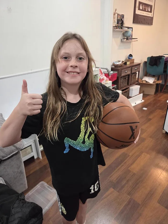 Happy customer giving a thumbs-up while holding her YGA Silent Basketball