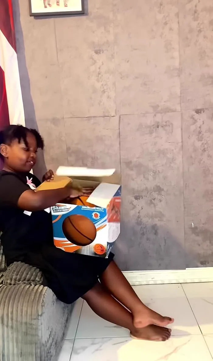 Young customer unboxing his YGA Silent Basketball at home