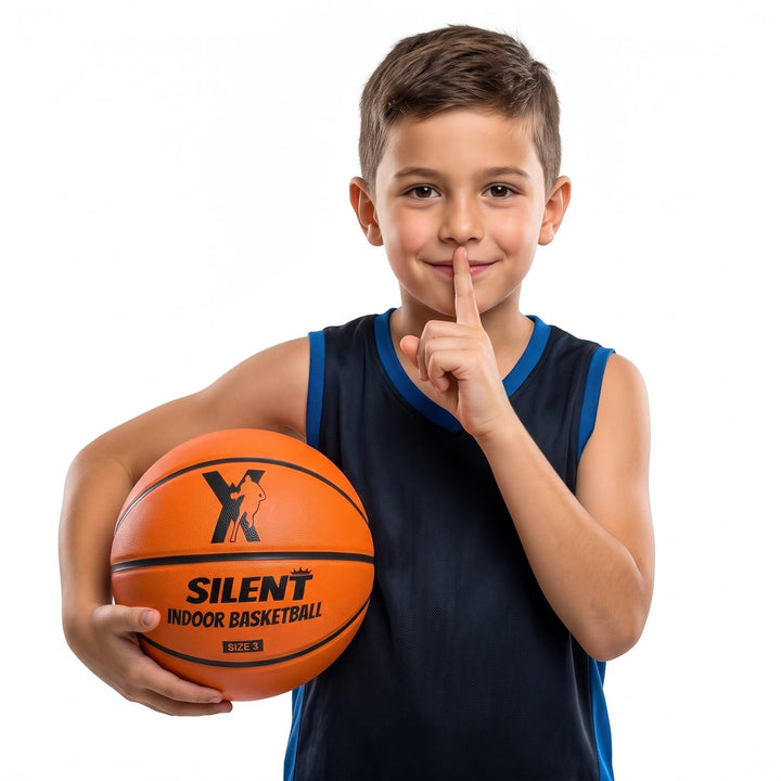 Boy holding the YGA Silent Basketball Size 3 with a finger to his lips - the quiet indoor basketball for kids